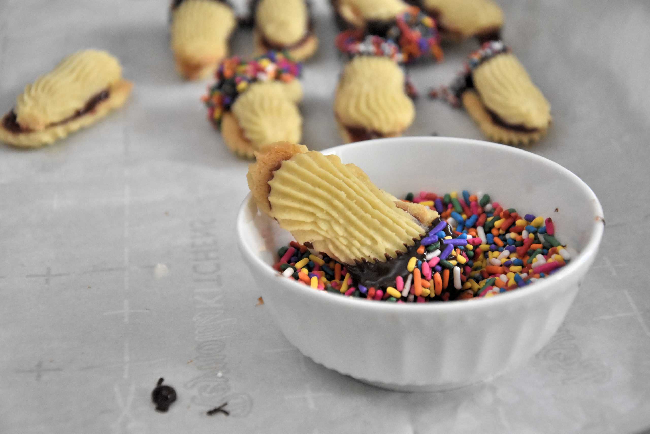 cookies being dipped in sprinkles