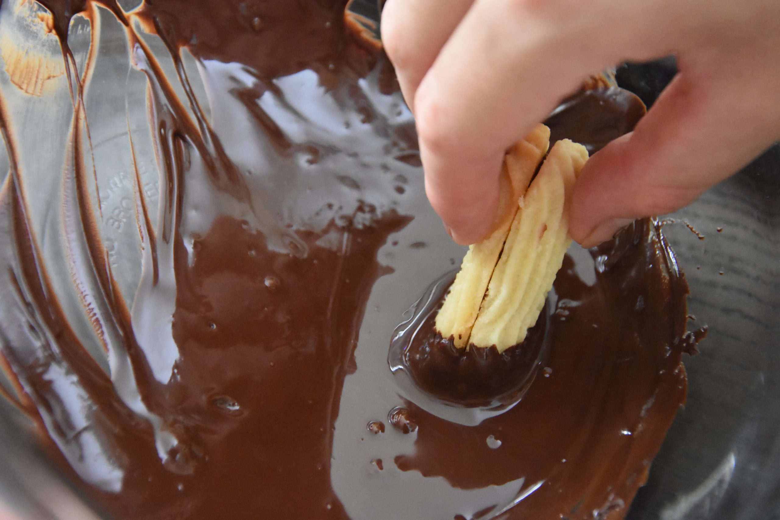 Cookie being dipped in chocolate